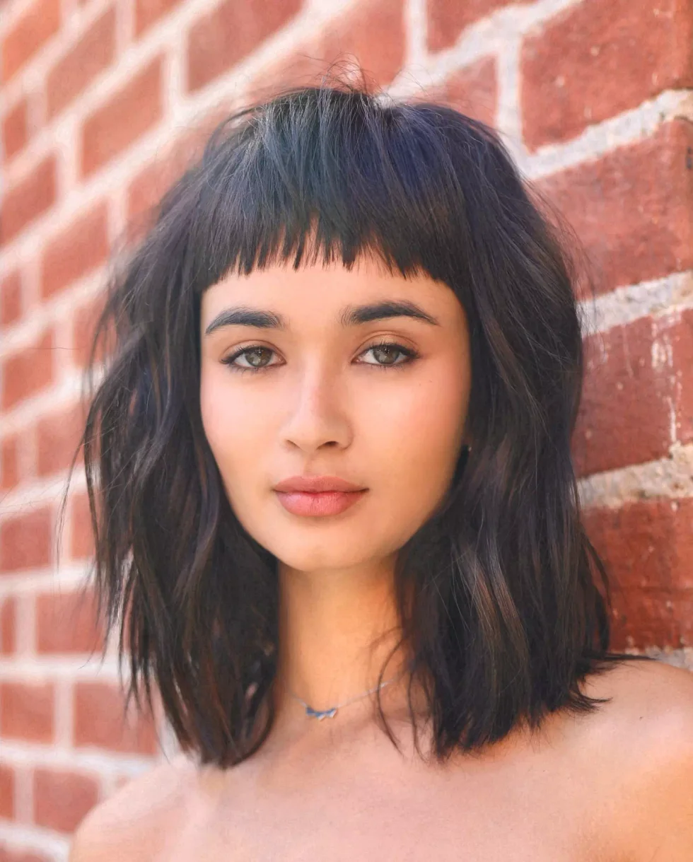 Blunt black baby bangs on long straight hair