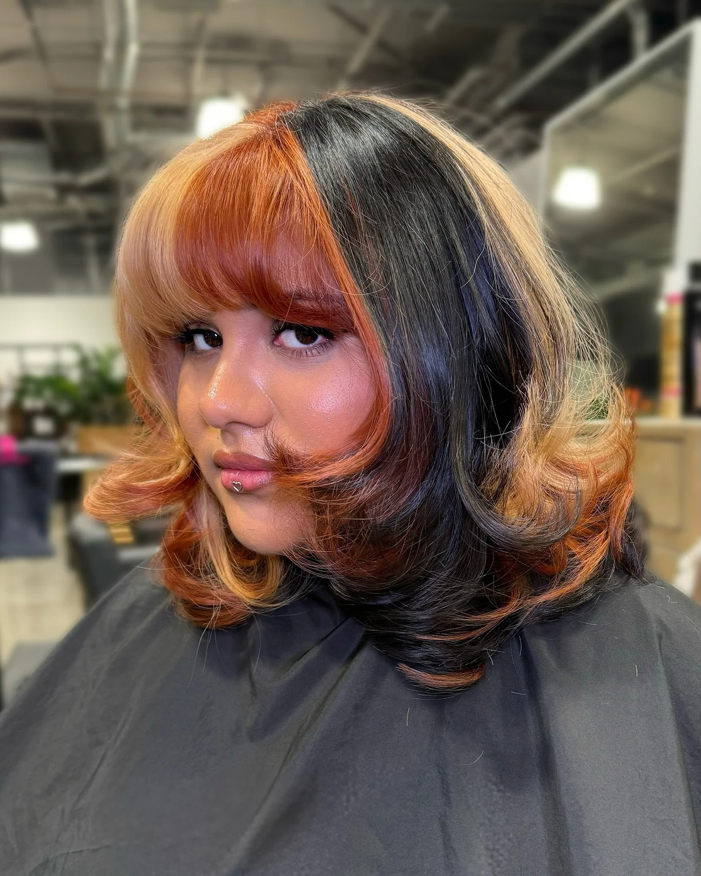 Rounded bob haircut with curtain bangs and soft cheek framing for a round face