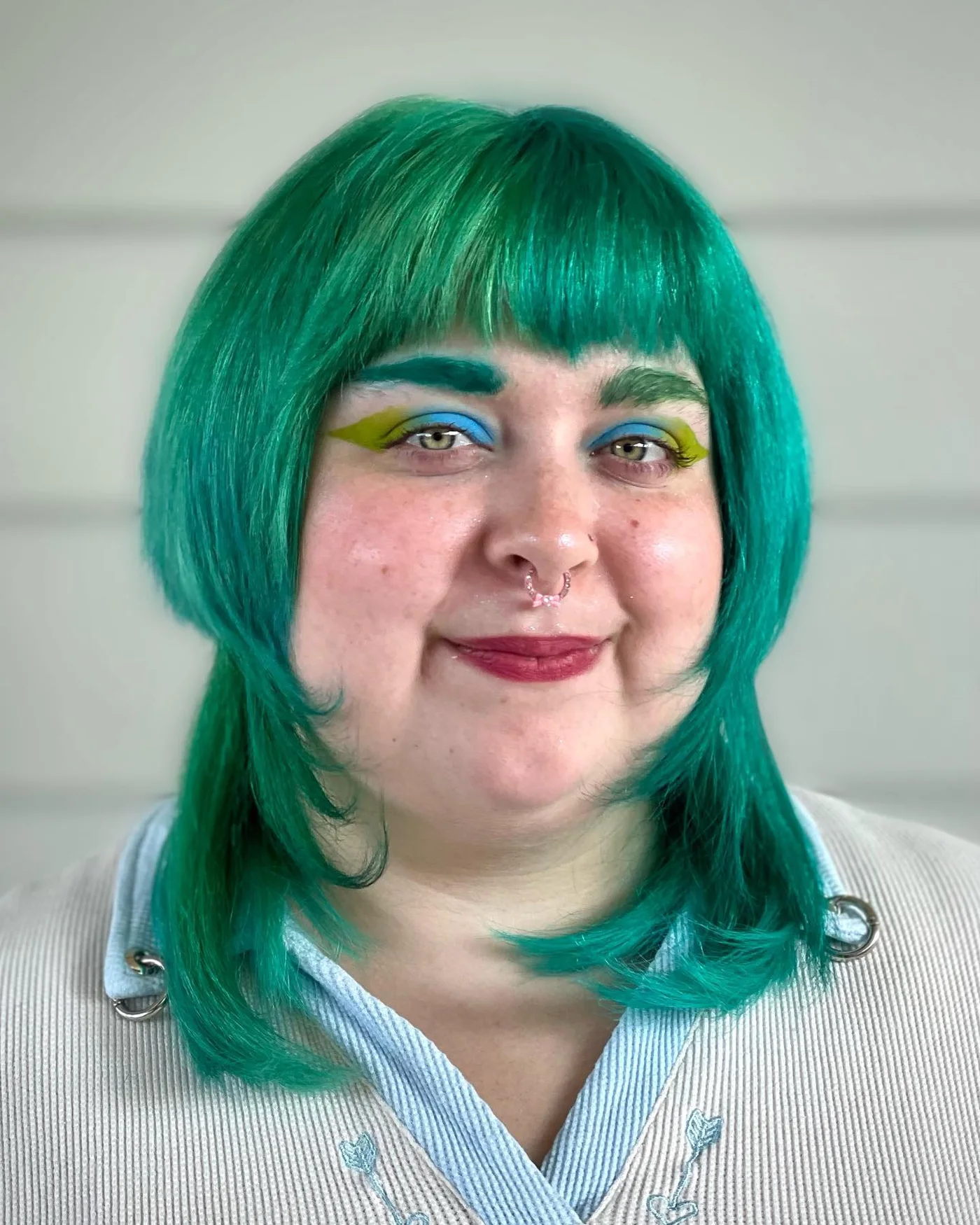 Green blunt bob with straight bangs and rounded face framing