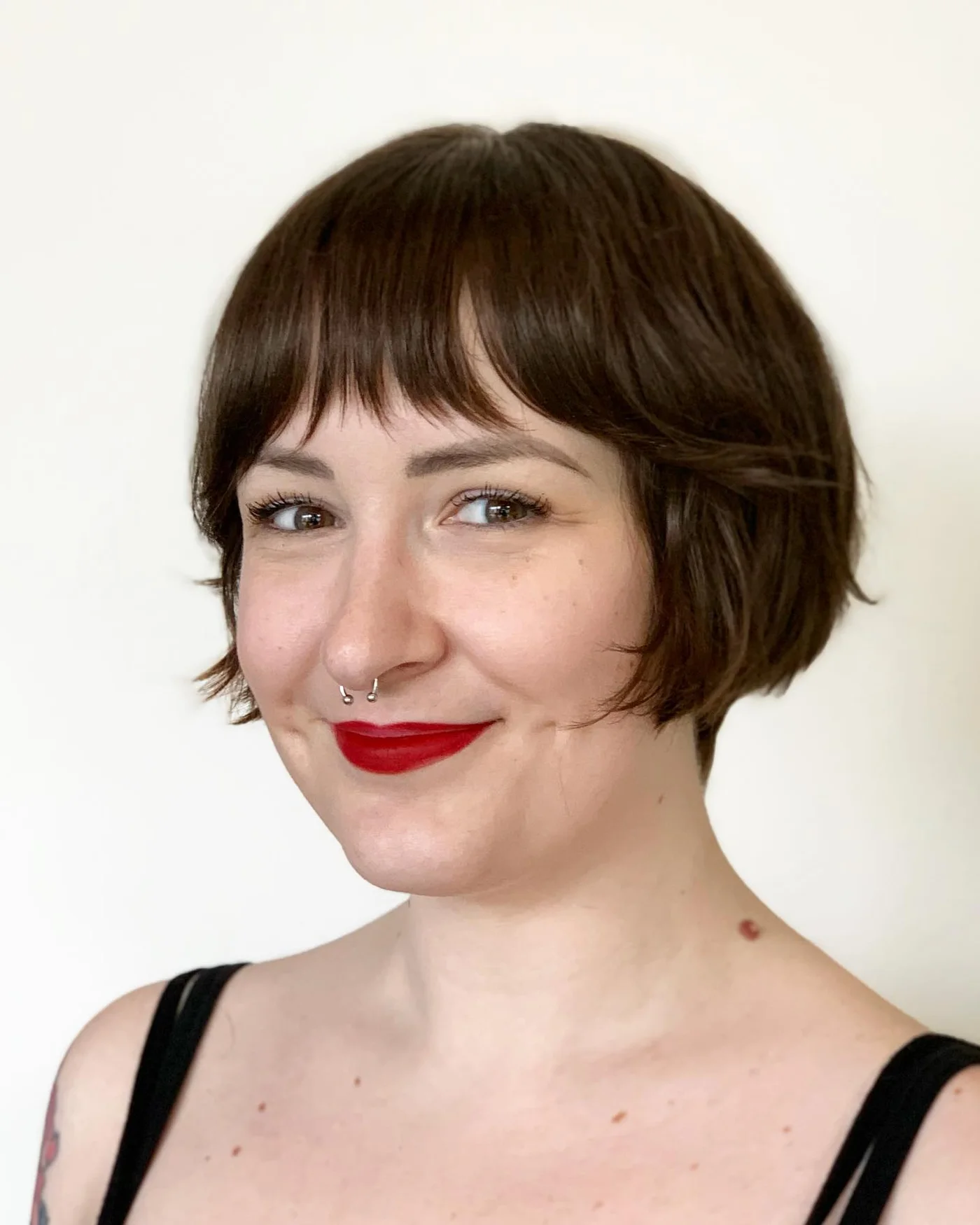 Soft blunt brunette bob with full bangs for a round face