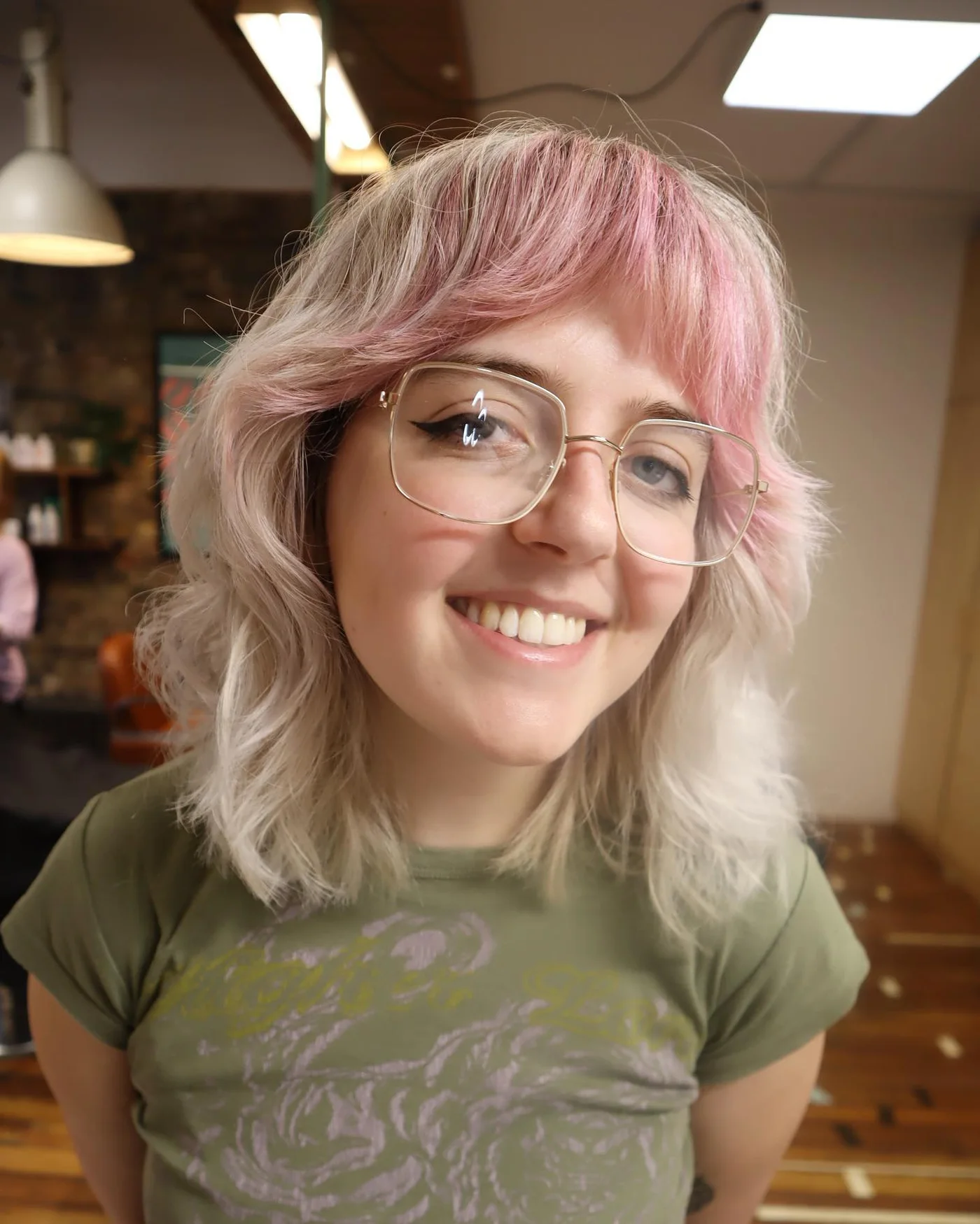 Pink shag haircut with wispy bangs and soft round face framing