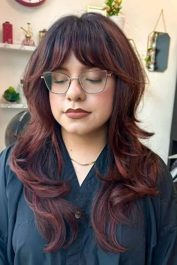 Red shag hairstyle with curtain bangs and face-framing layers