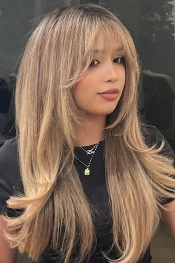 Blonde face-framing layers with curtain bangs for a round face