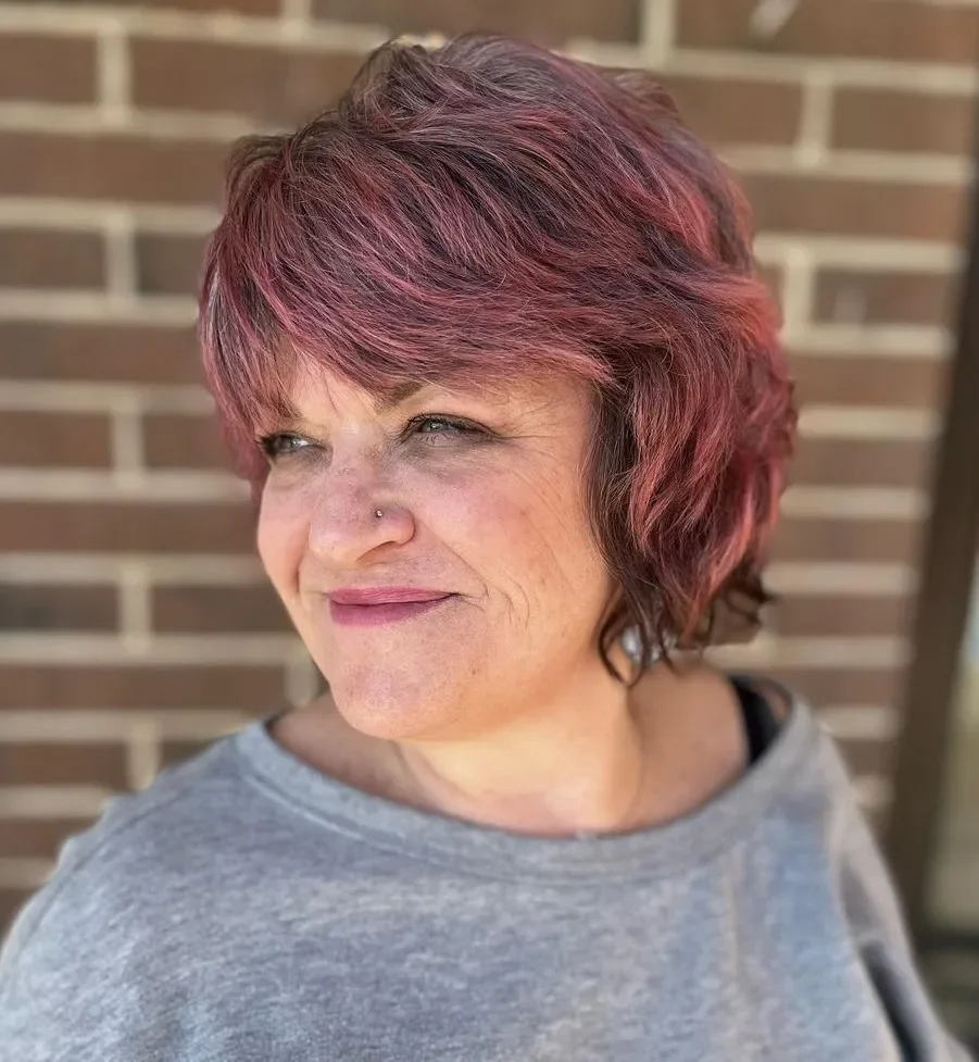Berry colored pixie cut with side-swept bangs for a round face