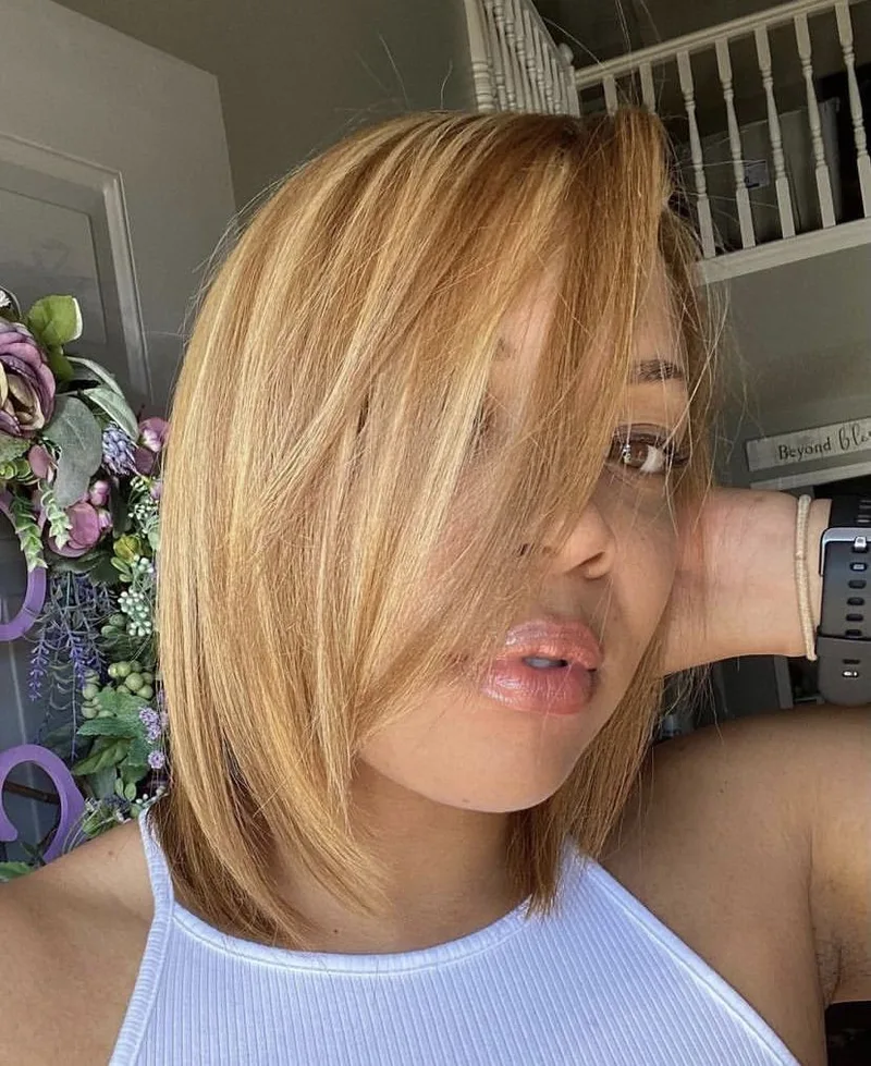 Smooth blonde bob with a side part and softly curved ends, shown as hairstyle inspiration.