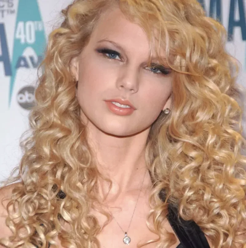 Long blonde ringlets and a softly parted crown, shown as hairstyle inspiration.