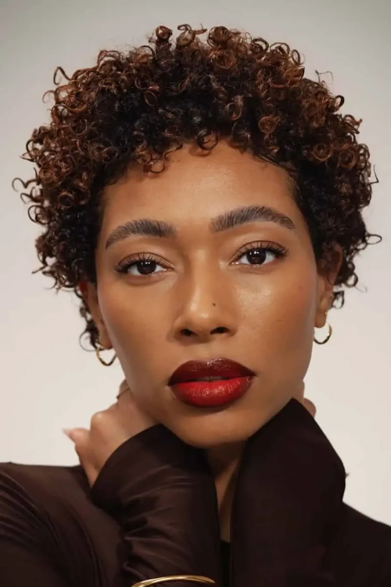 Short brown curls with a closely shaped side, shown as hairstyle inspiration.