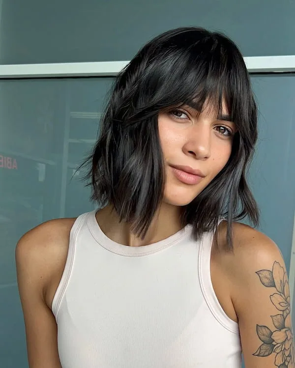 Dark shoulder-length bob with a long fringe