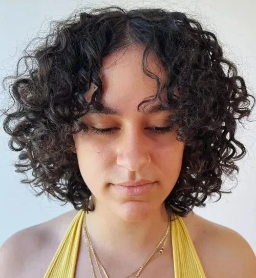 Woman with a dark curly bob and softly defined curls