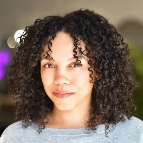 Dark shoulder-length curls with dense softly arranged layers