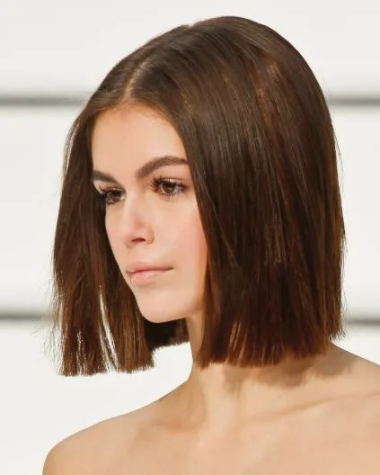 Woman with a smooth blunt brunette bob and center part