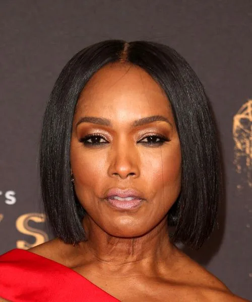 Woman with a sleek dark chin-length bob and a centre part