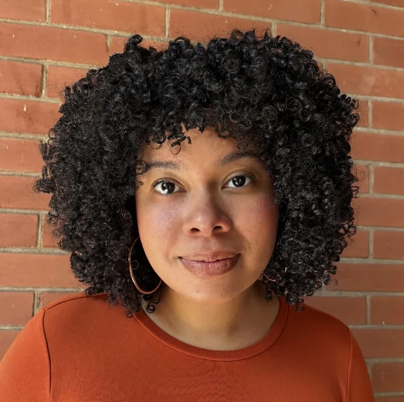 Woman with a rounded dark curly bob and defined ringlets