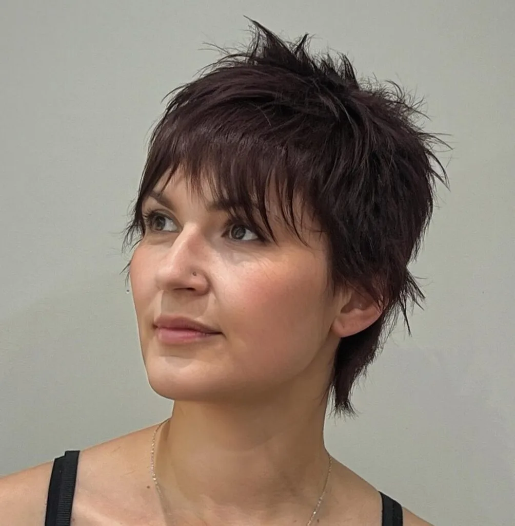 ear straight brunette pixie with side swept fringe shown as a bixie haircut idea