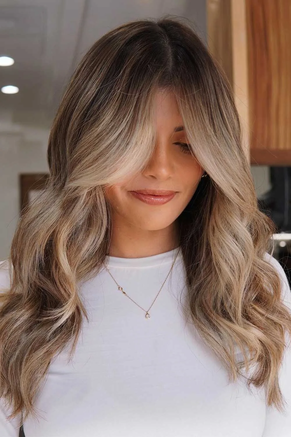 Darker blonde waves with a brown crown and brighter long front pieces