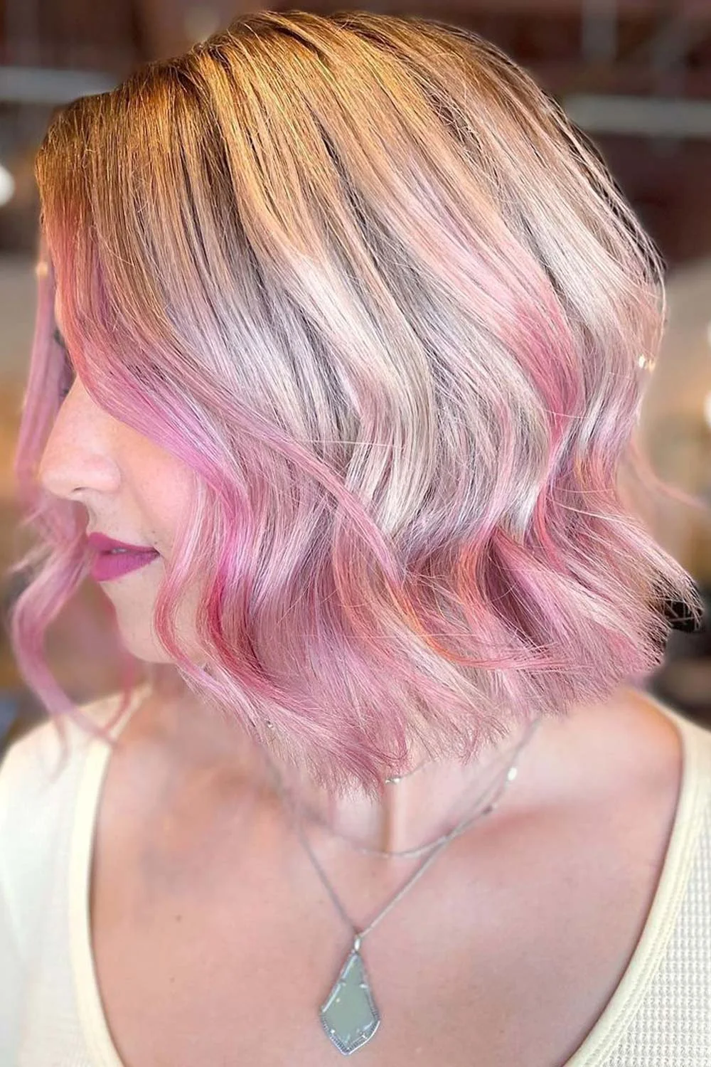 Wavy blonde bob with pale pink sections through the sides