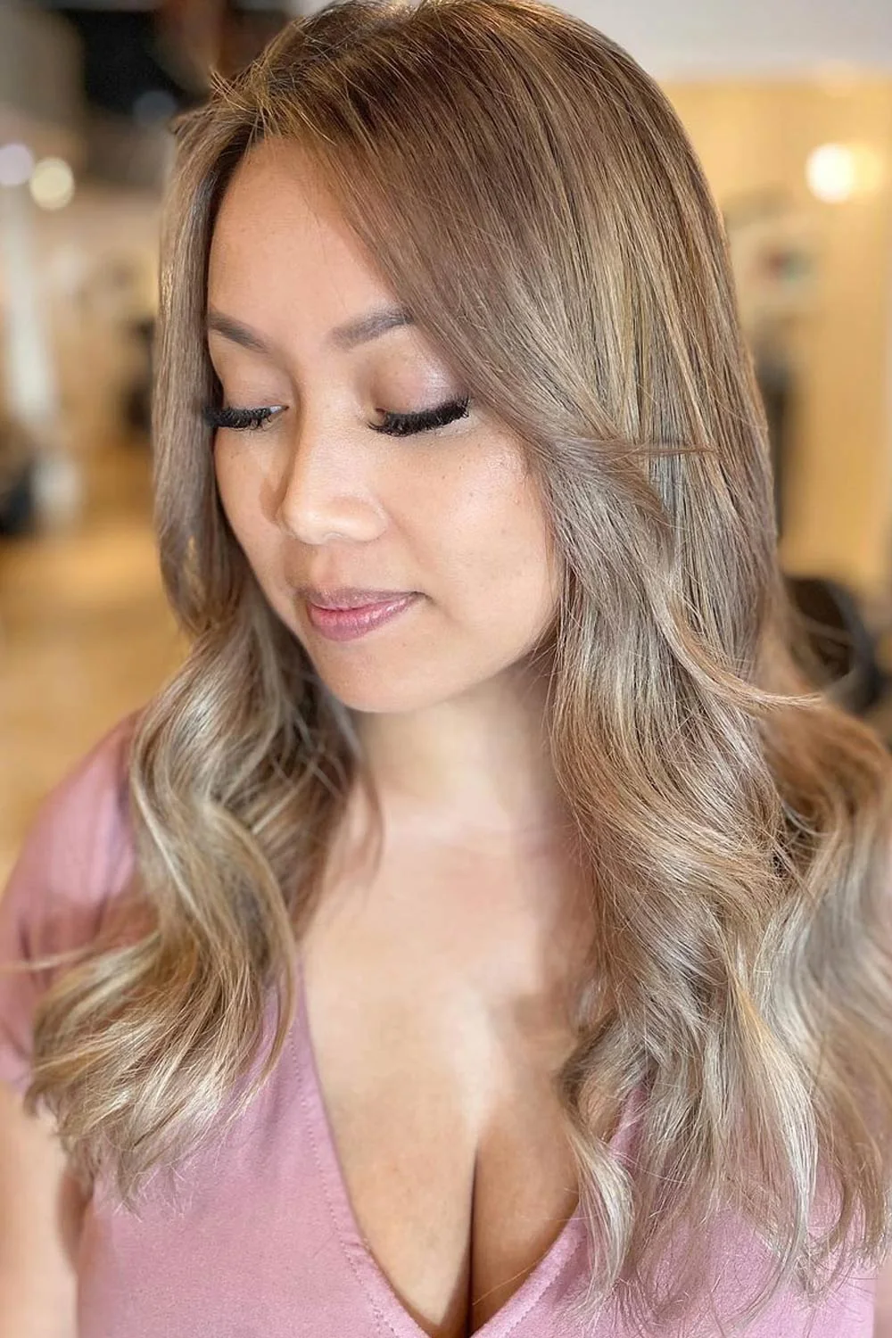 Long sandy blonde waves with a deeper upper section and softly bright ends
