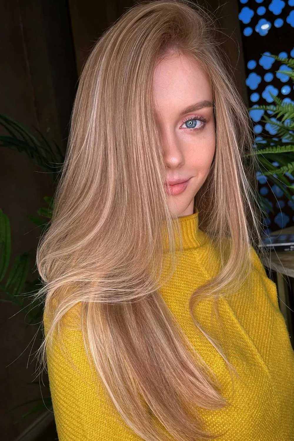 Long smooth honey blonde hair with a side opening and curved ends