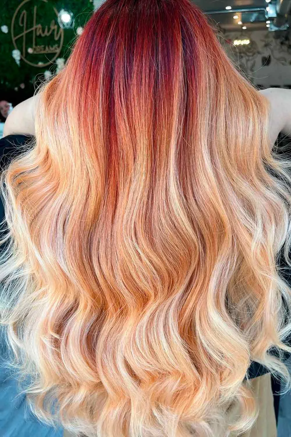 Back view of warm red-gold roots blending into pale golden waves