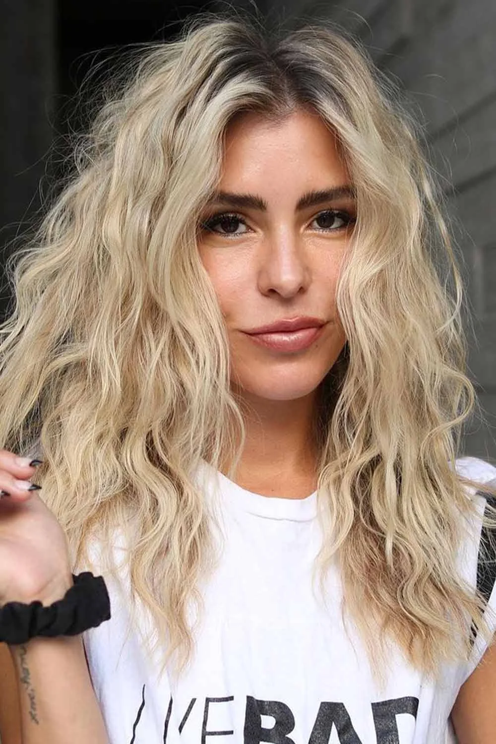 Creamy blonde textured waves with darker roots and separated ends