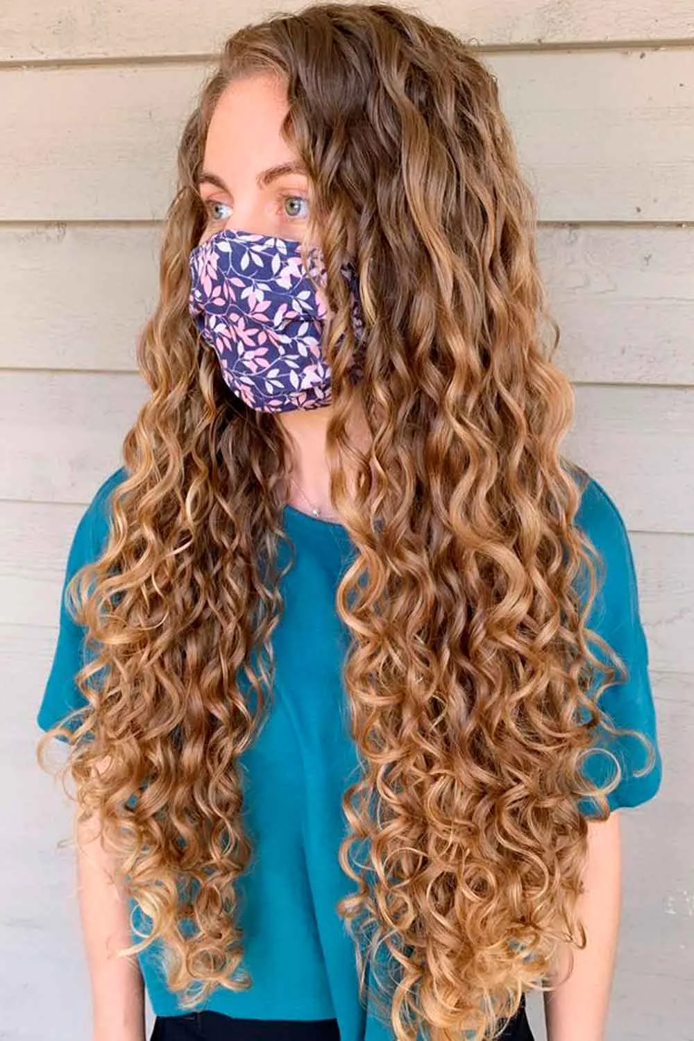 Long curls with honey-gold highlights over a deeper brown base