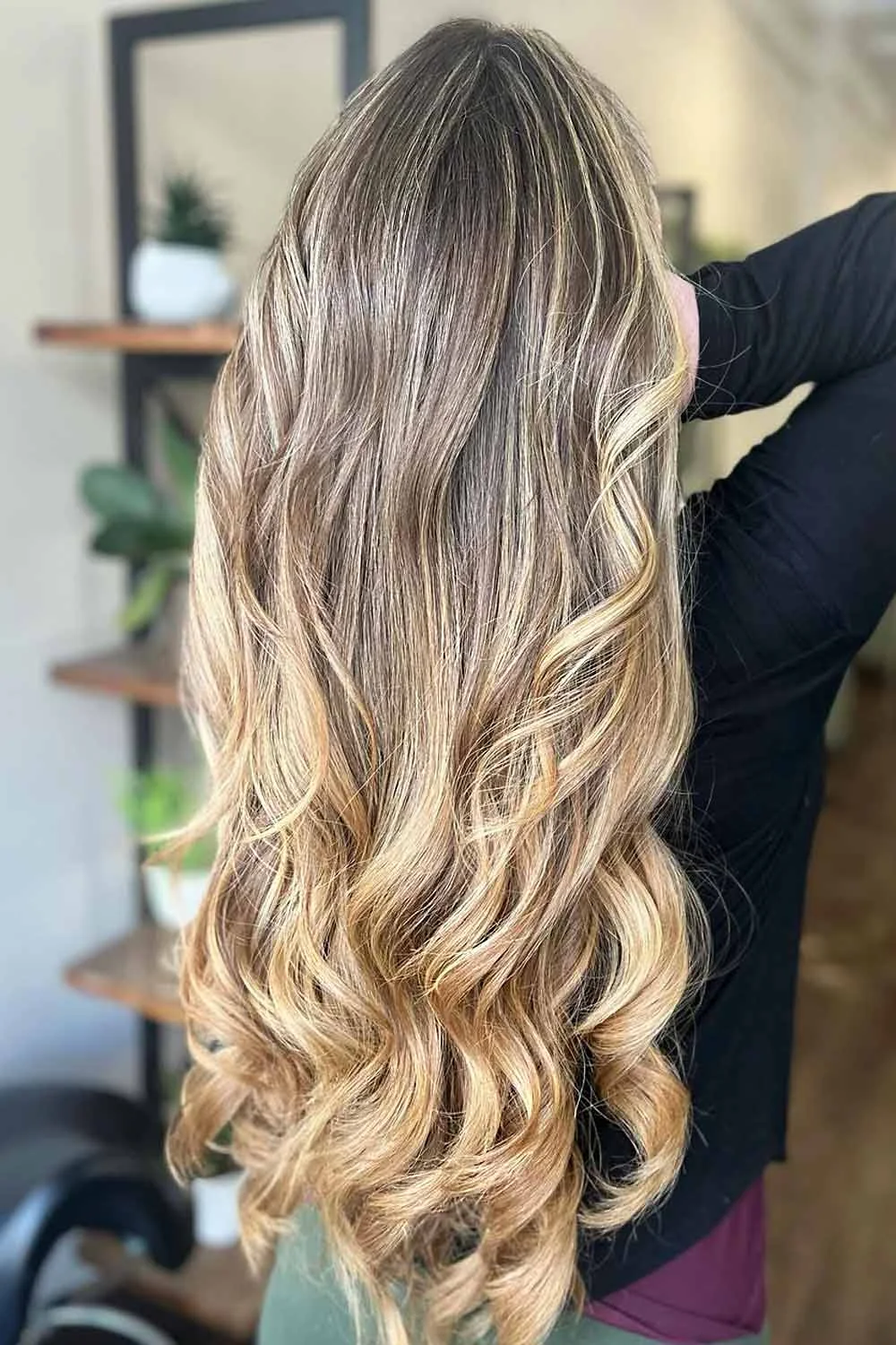 Back-side view of long brown hair with golden blonde lower curls