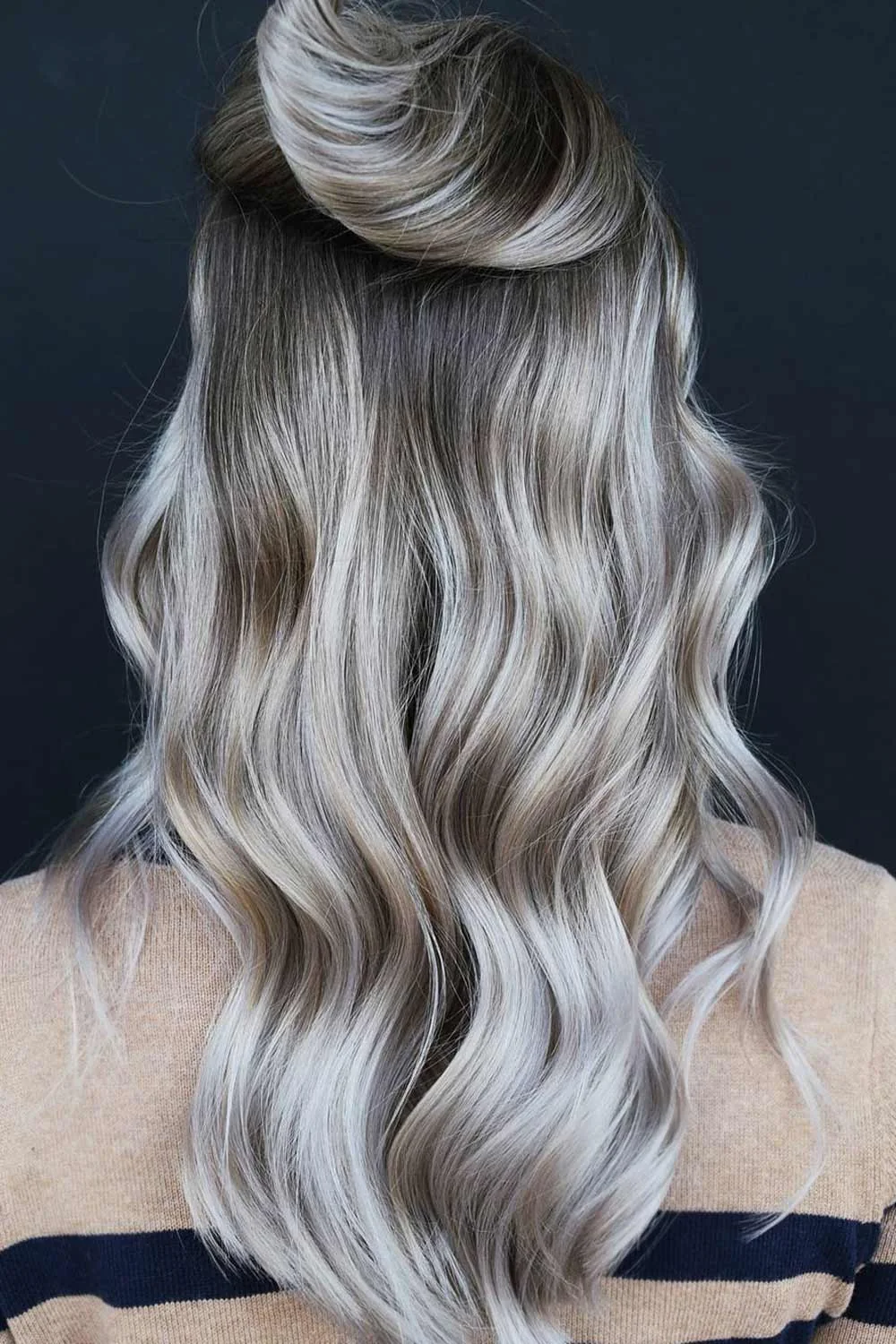 Back view of long cool pale waves with a dark root area and small gathered crown section