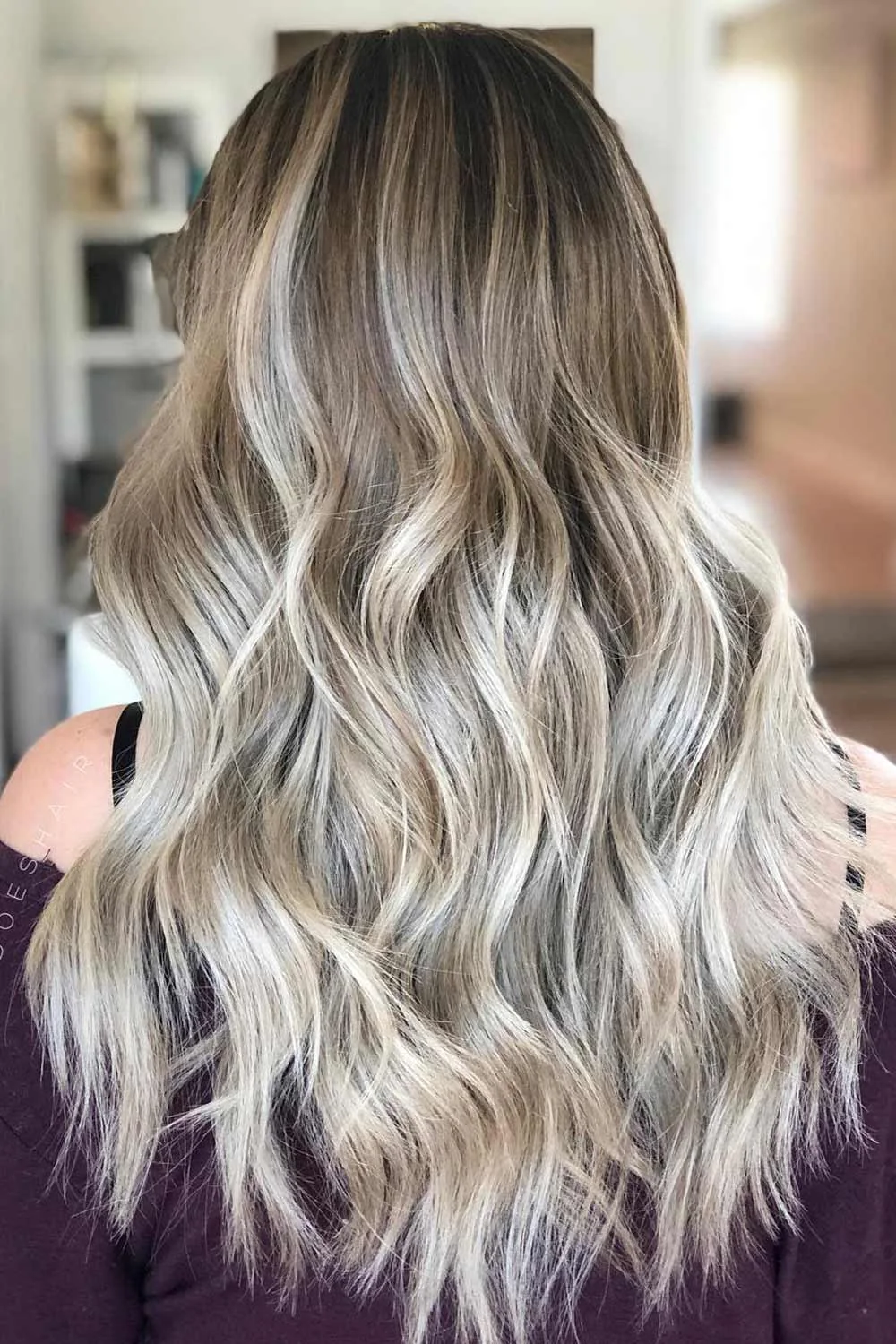 Back view of shoulder-and-longer hair with a brown crown and cool pale blonde waves