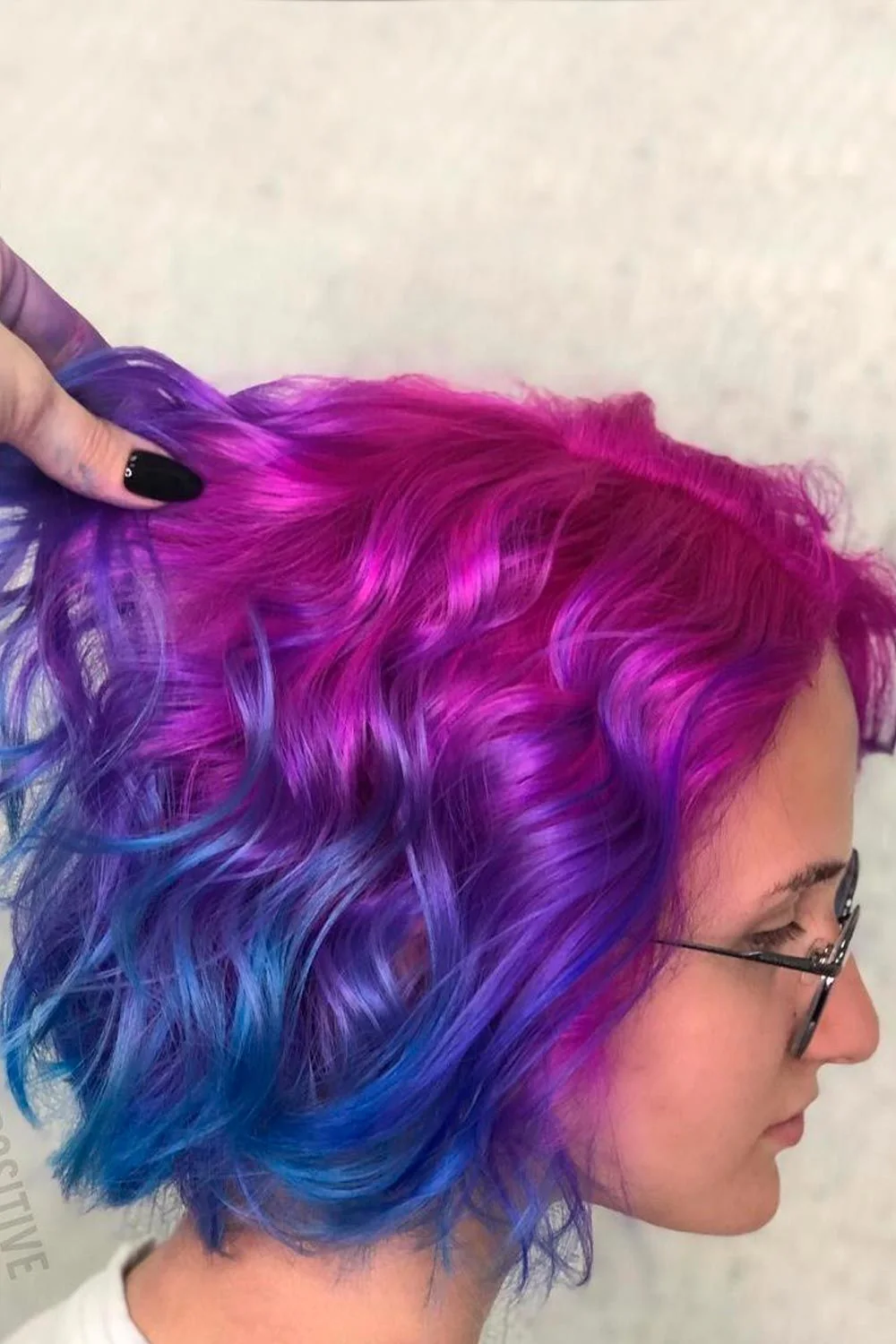 Wavy bob with a berry-purple upper section and vivid blue lower curls