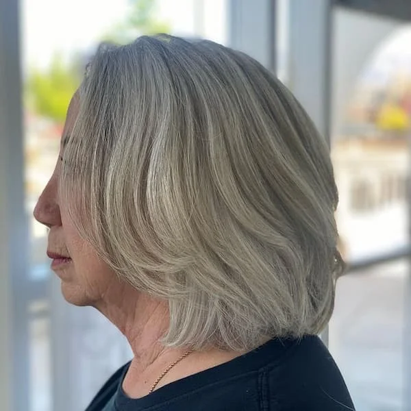 Side view of a gray neck-length bob with soft layering