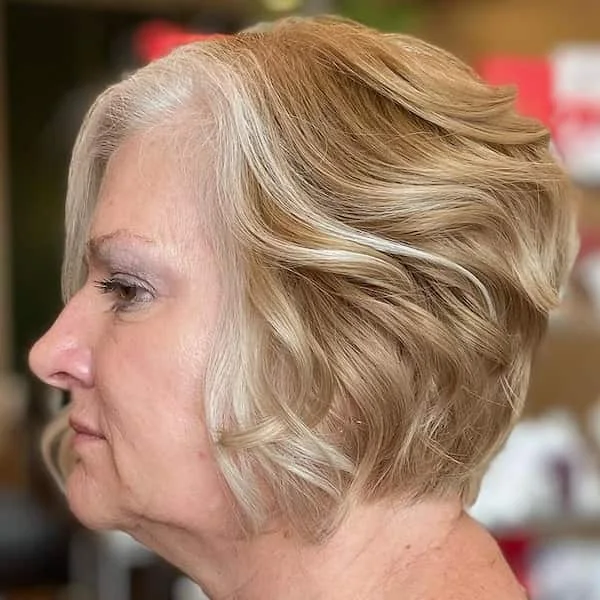 Side view of a blonde wavy neck bob with soft volume