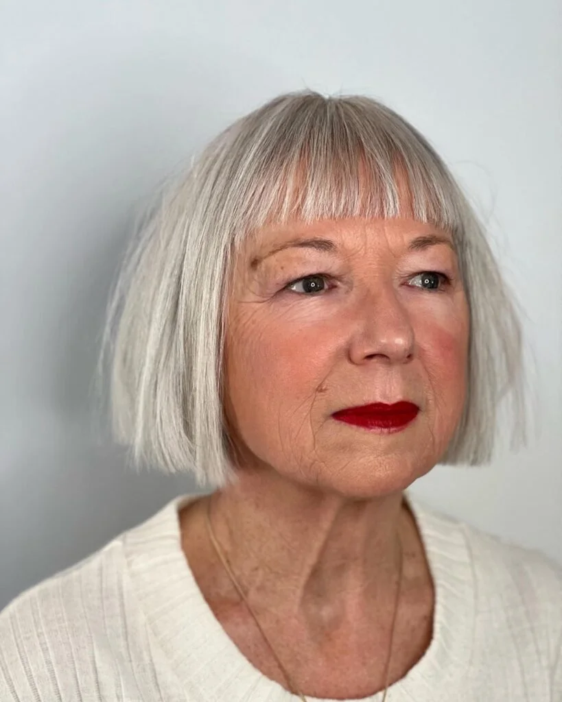 Blunt gray chin bob with short bangs and red lipstick