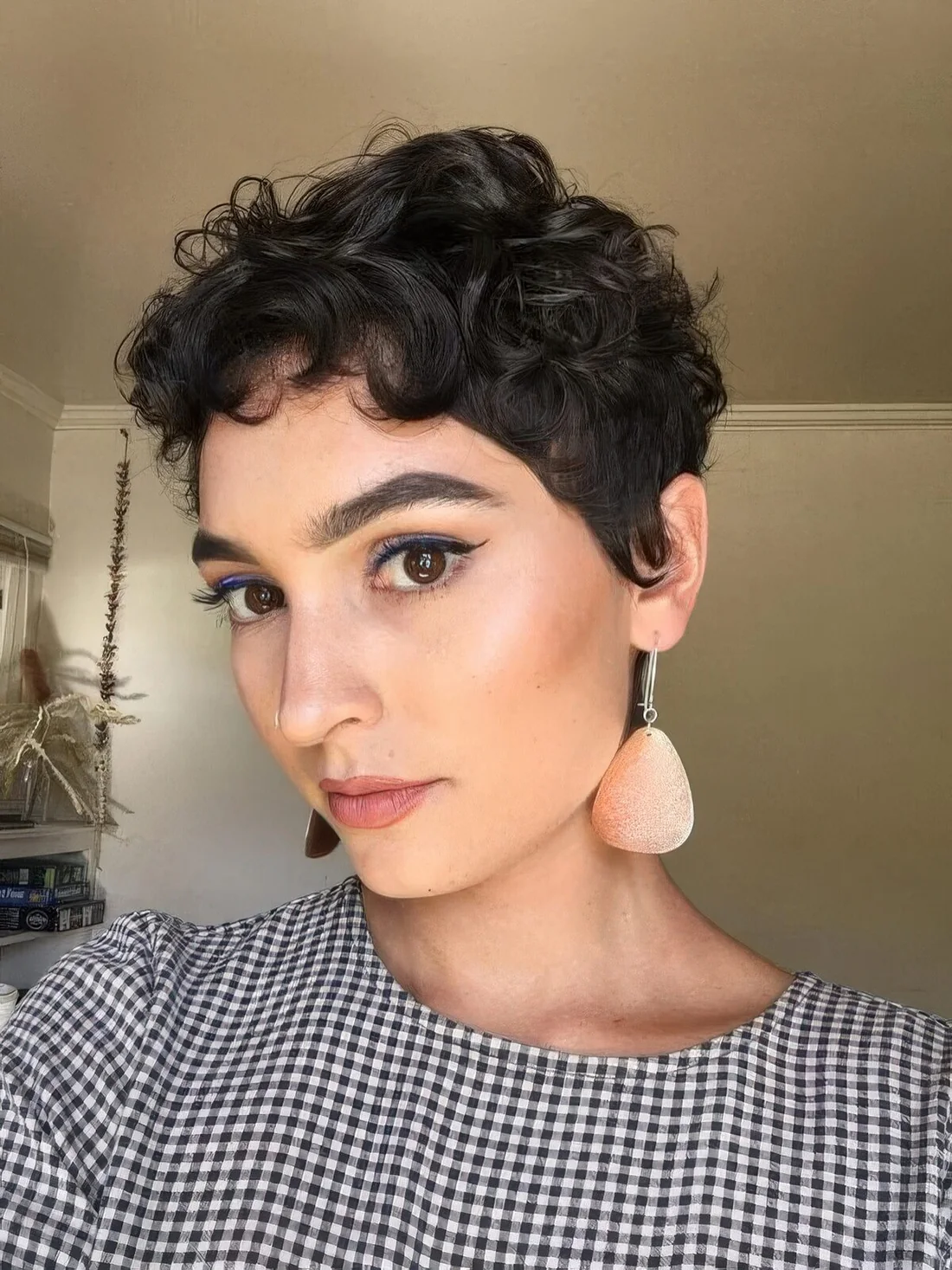 Almost black wavy pixie with a bit of bangs and longer sides.