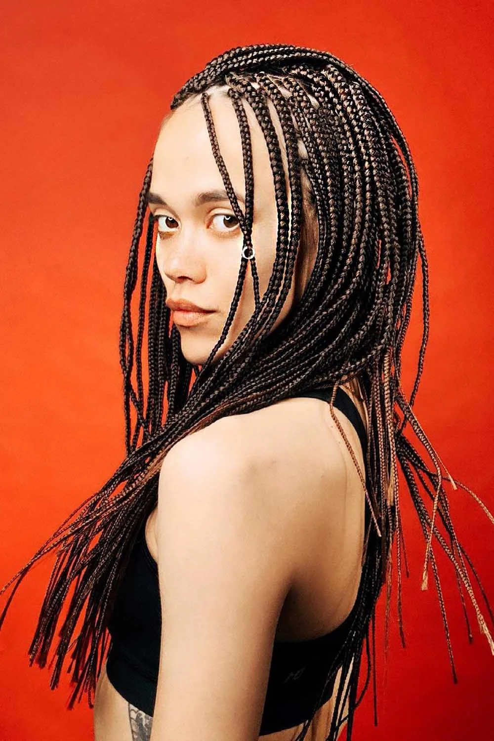 Front-side view of long dark braids with silver rings along several front sections