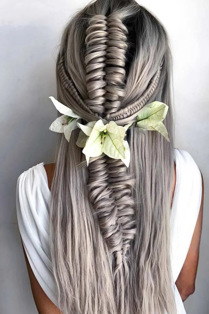 Back view of long pale hair with a fine central braid and pale flowers around its middle join
