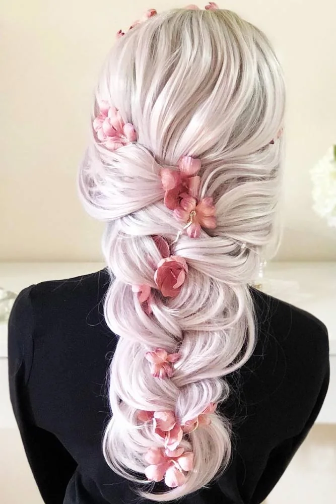 Back view of pale hair with large looped braided sections and pink flower accents