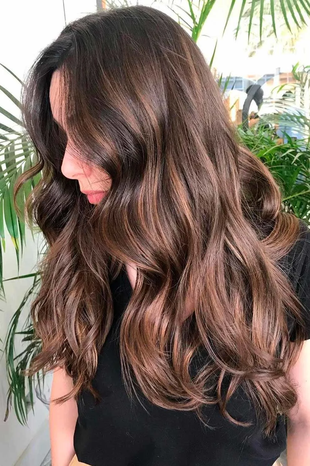 Front-side view of long brown waves with restrained warm lighter strands