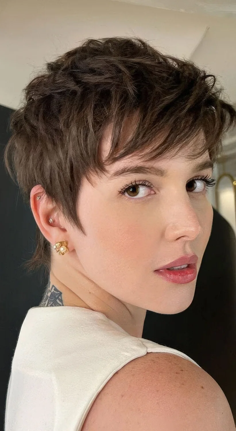 Layered long brunette pixie haircut with bangs and volume.