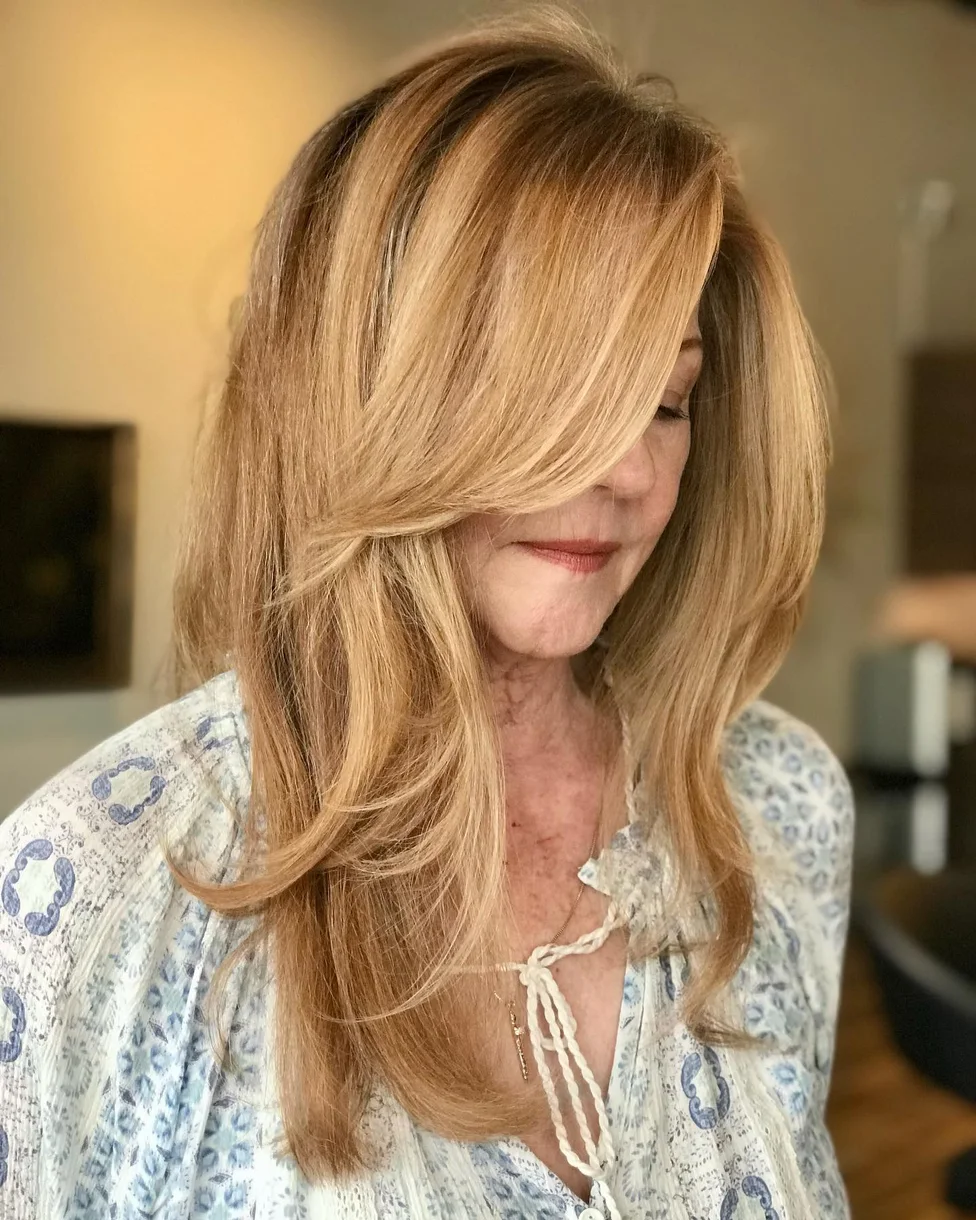 Honey blonde long butterfly haircut with curtain-like front layers