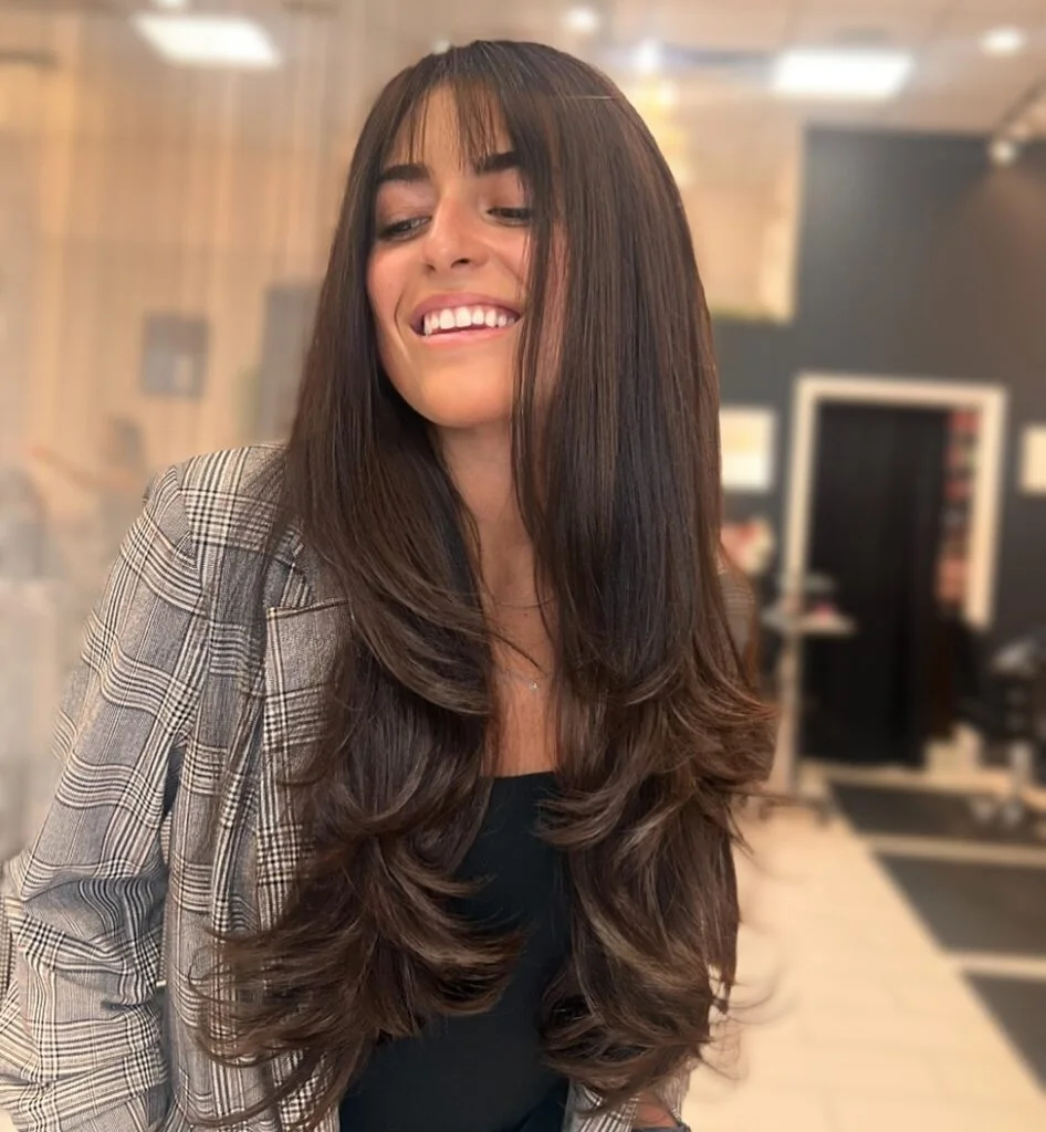 Long brunette butterfly haircut with a soft layered blowout