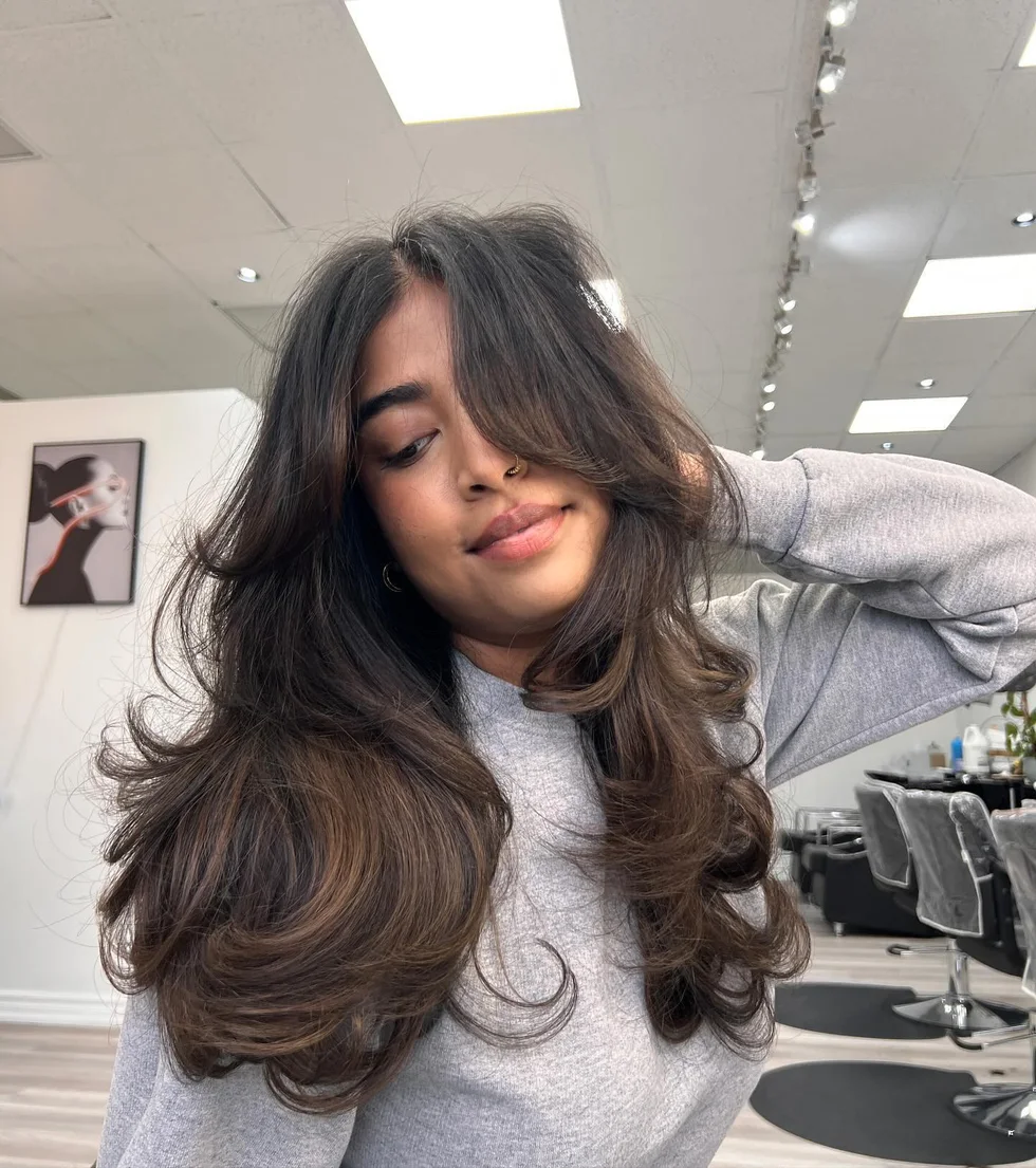 Thick brunette long butterfly haircut with full layered volume
