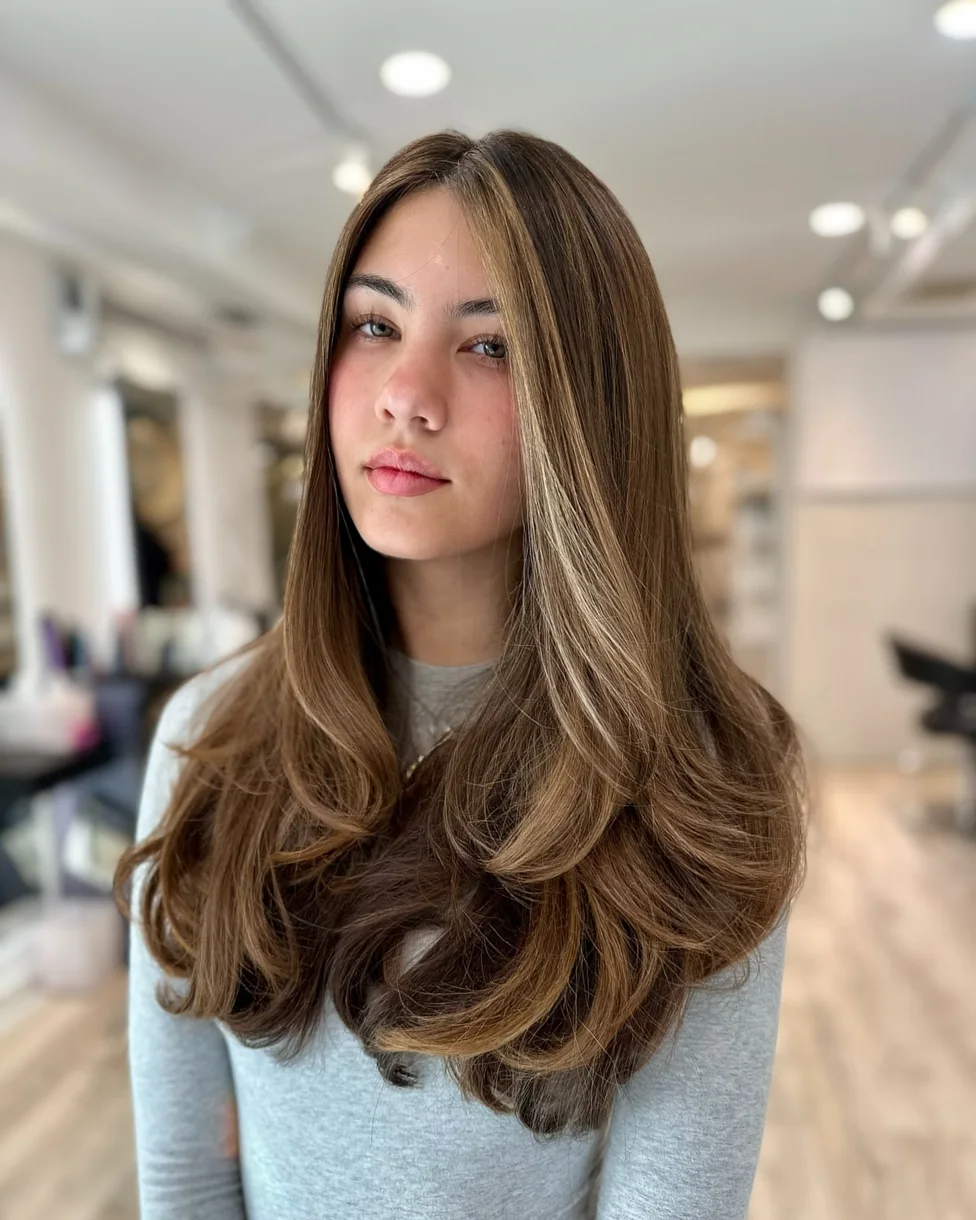 Dimensional brunette butterfly haircut with long highlighted layers
