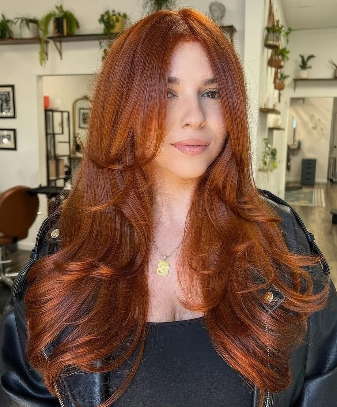 Copper long butterfly haircut with face-framing layers and curled ends.