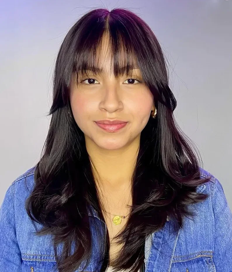 chest wavy black bangs with wispy fringe shown as a butterfly haircuts with bangs idea