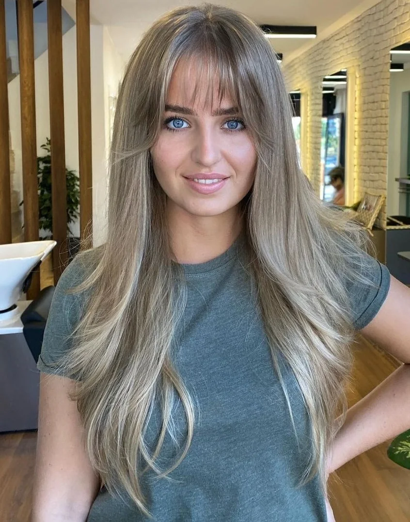 chest straight blonde layers with wispy fringe shown as a butterfly haircuts with bangs idea