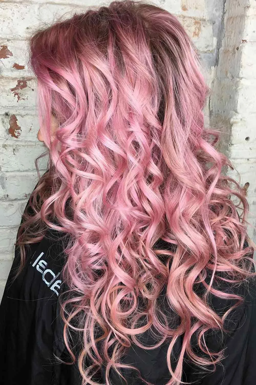 Back-side view of long layered hair with defined pale pink curls over a deeper rosy base