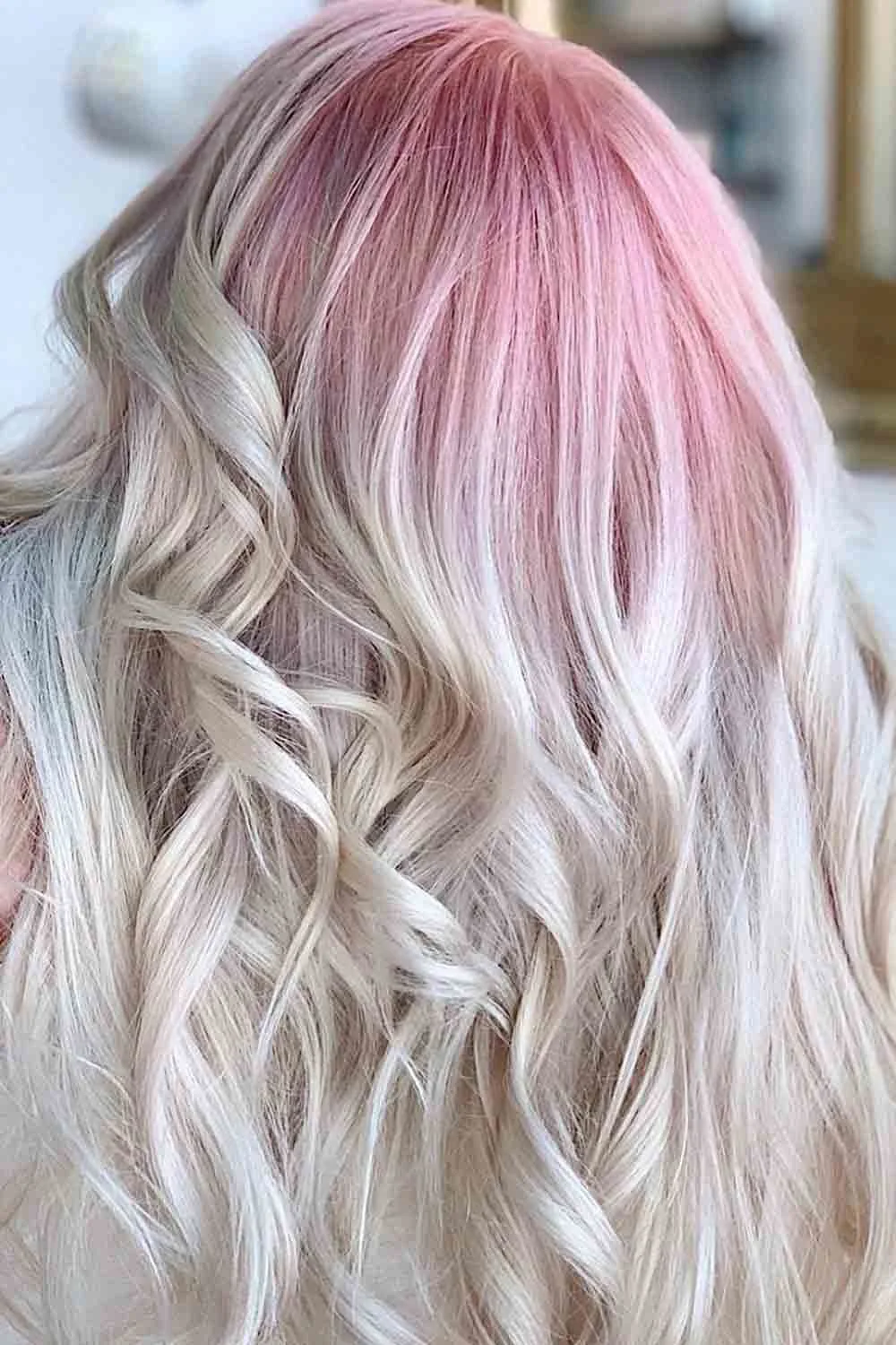 Back-side view of long waves with pale pink at the crown fading into near-white blonde ends