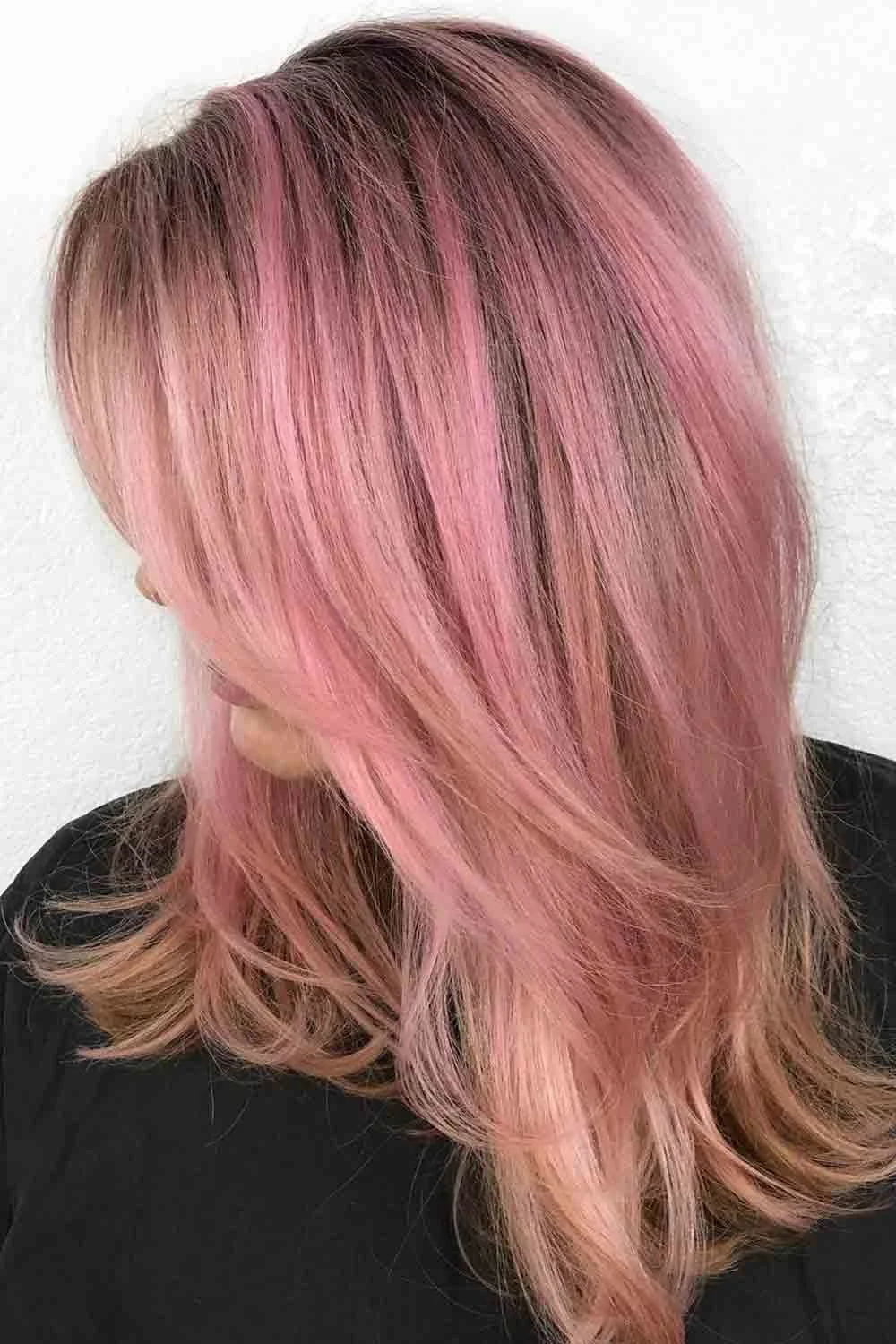 Side view of shoulder-length layers colored muted rose pink over a darker root area