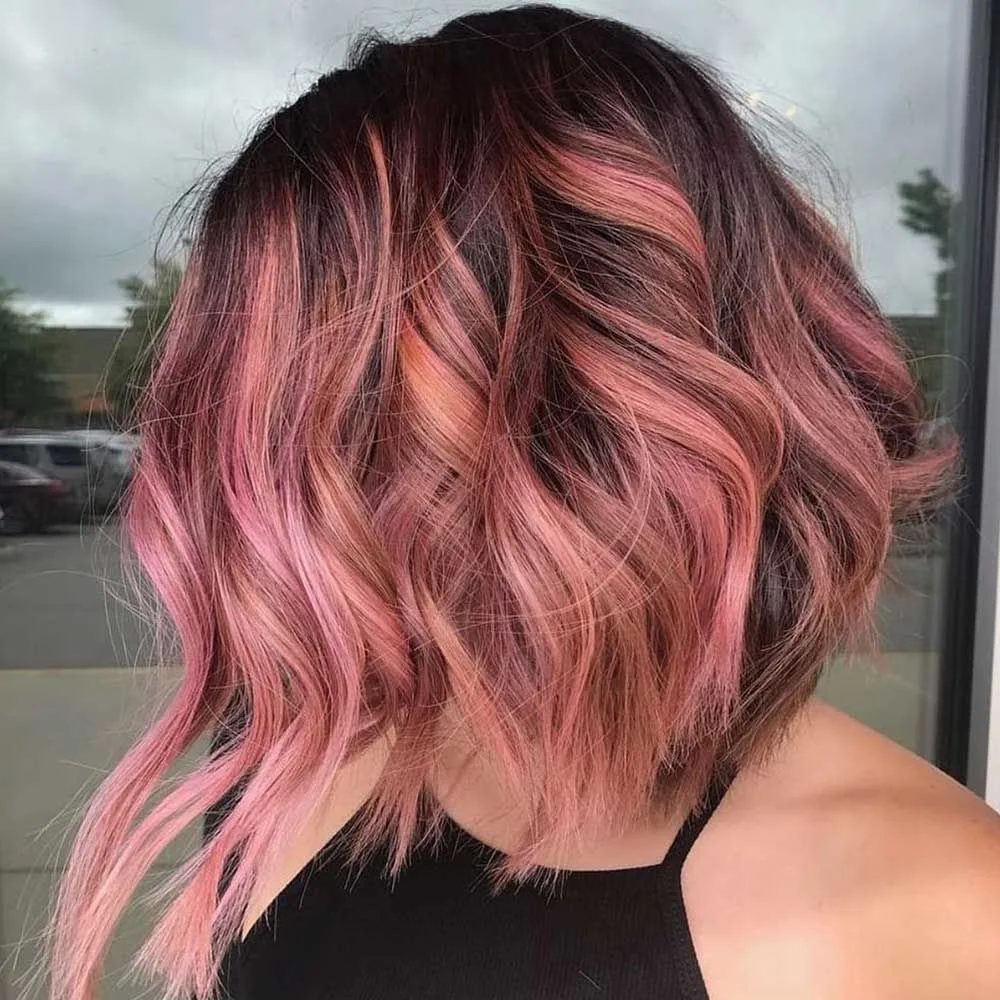 Back-side view of a wavy dark-brown lob with dusty pink balayage through the middle and ends