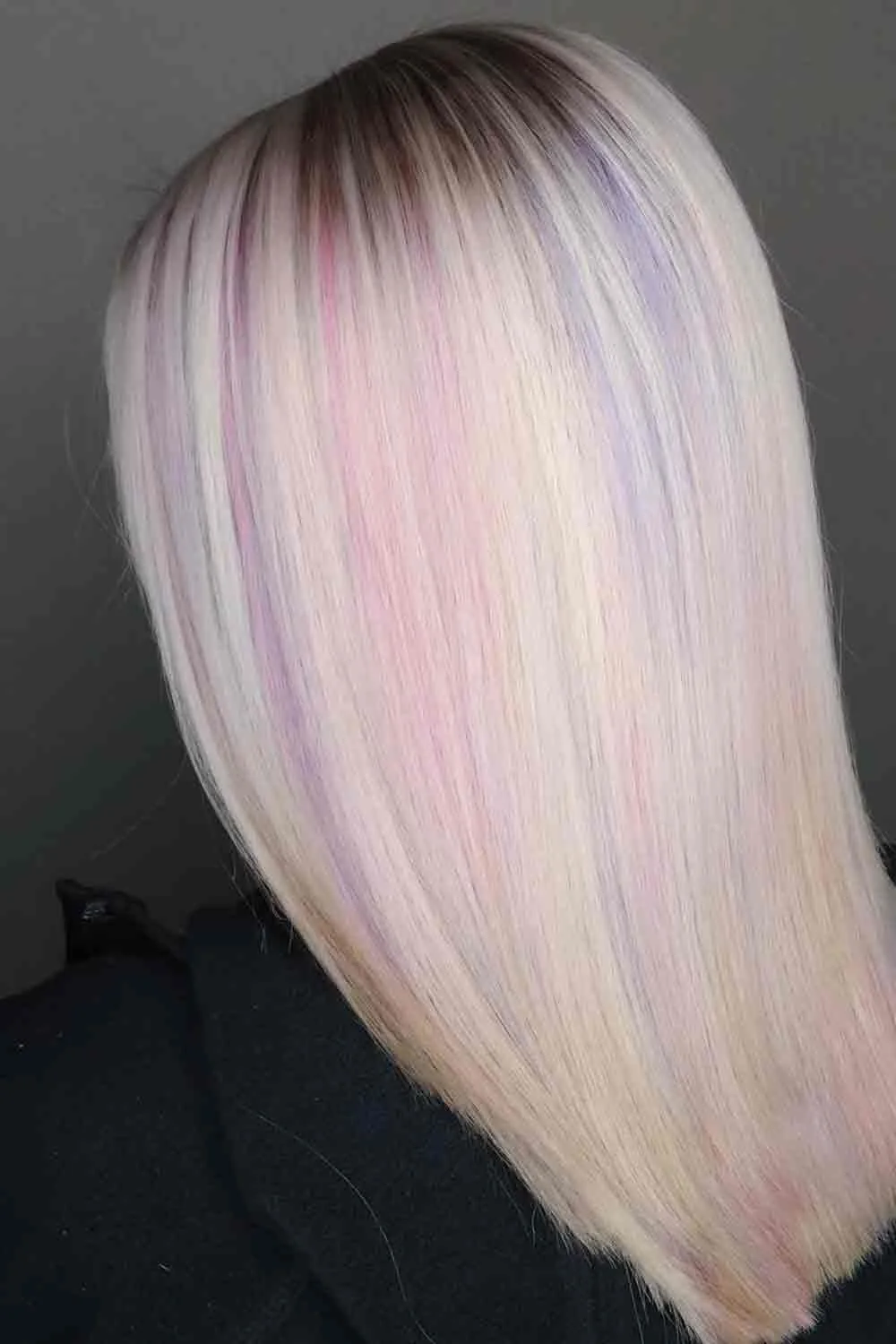 Back view of a straight platinum-blonde lob with a faint pink veil over the pale surface